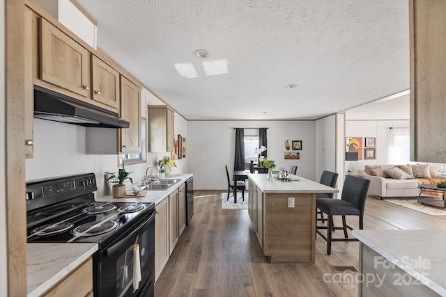 kitchen featuring electric range, dark wood-style floors, a kitchen island, under cabinet range hood, and a sink