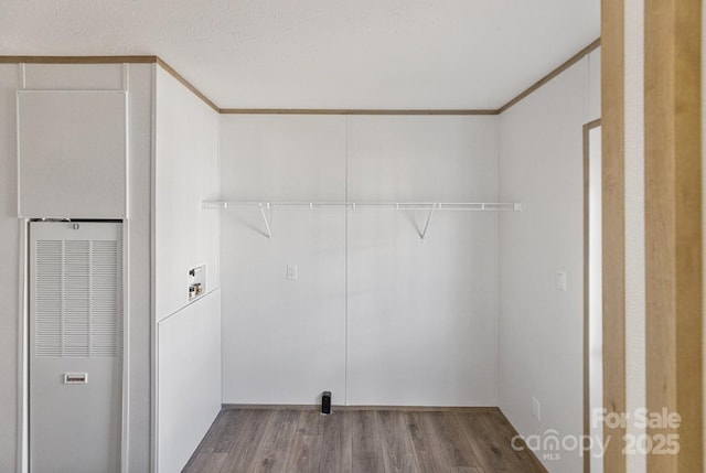 washroom featuring hookup for a washing machine, laundry area, wood finished floors, ornamental molding, and a heating unit