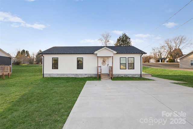 view of front of home with a shingled roof and a front lawn