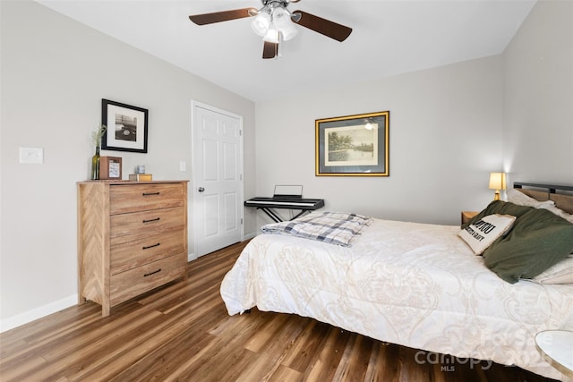 bedroom featuring a ceiling fan, dark wood finished floors, and baseboards