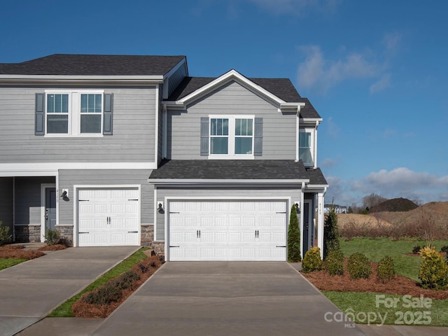 view of front facade featuring a garage, stone siding, and driveway