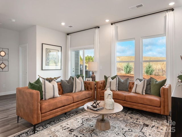 living room with baseboards, wood finished floors, visible vents, and recessed lighting