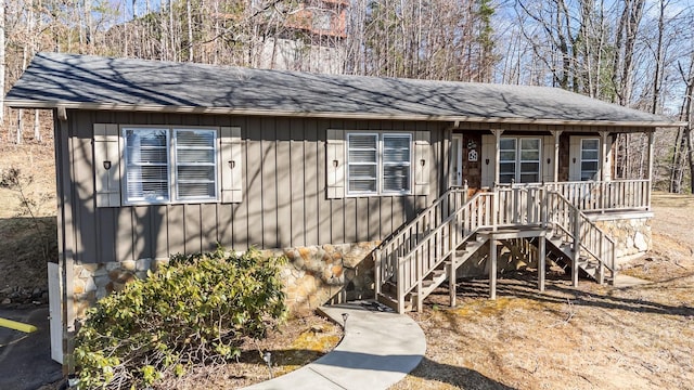 view of front of home with stairs and a shingled roof