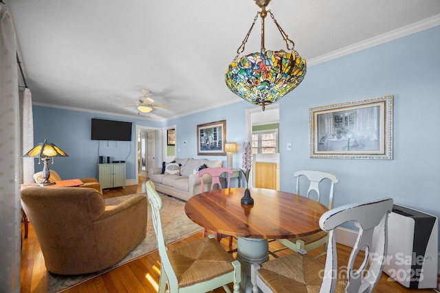 dining area with ornamental molding, wood finished floors, and a ceiling fan