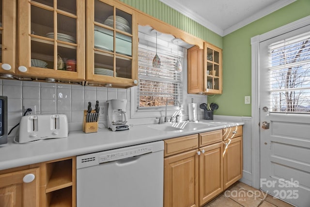 kitchen featuring dishwasher, light countertops, a sink, and glass insert cabinets