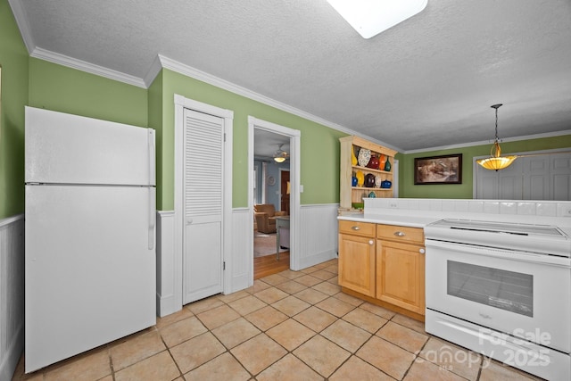 kitchen with white appliances, wainscoting, light countertops, a textured ceiling, and pendant lighting