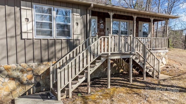 doorway to property featuring stone siding and board and batten siding