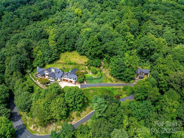 drone / aerial view with a wooded view