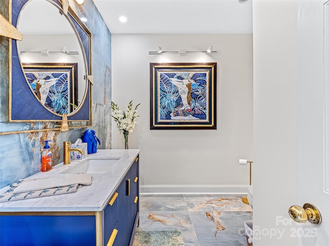 bathroom featuring toilet, decorative backsplash, vanity, and baseboards