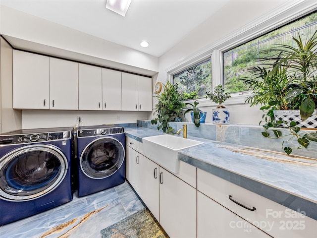 washroom with washing machine and clothes dryer, a sink, cabinet space, and recessed lighting