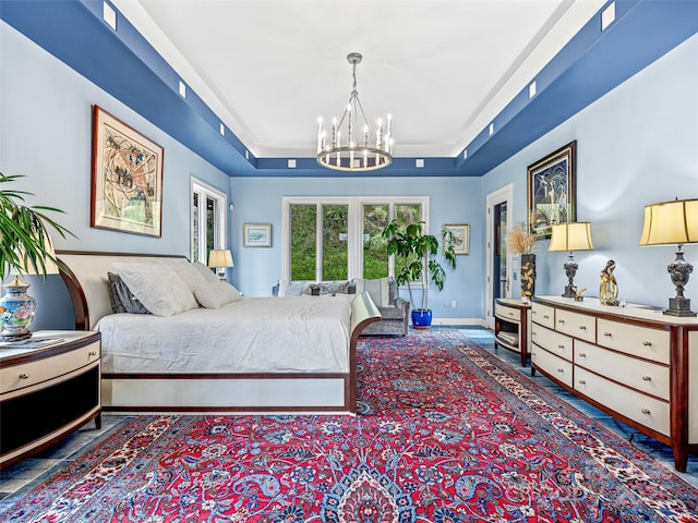 bedroom with baseboards, a tray ceiling, and a notable chandelier