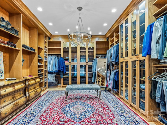 walk in closet with a notable chandelier