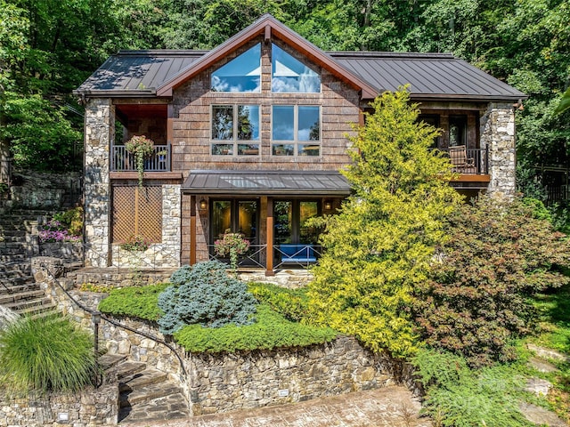 chalet / cabin with a standing seam roof, stone siding, metal roof, and french doors