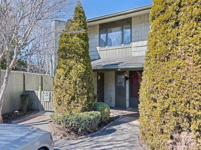 view of front of property with a shingled roof and fence