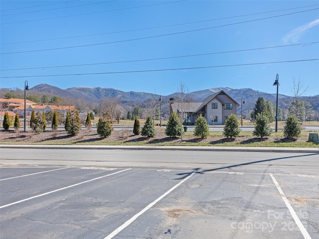 view of road featuring street lighting, curbs, and a mountain view