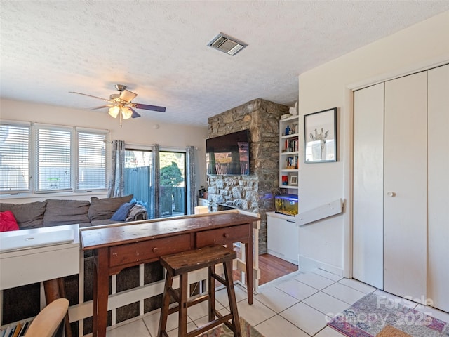 kitchen featuring visible vents, ceiling fan, a textured ceiling, and light tile patterned floors