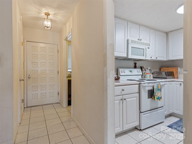 kitchen with white appliances, light tile patterned floors, white cabinets, light countertops, and a textured ceiling