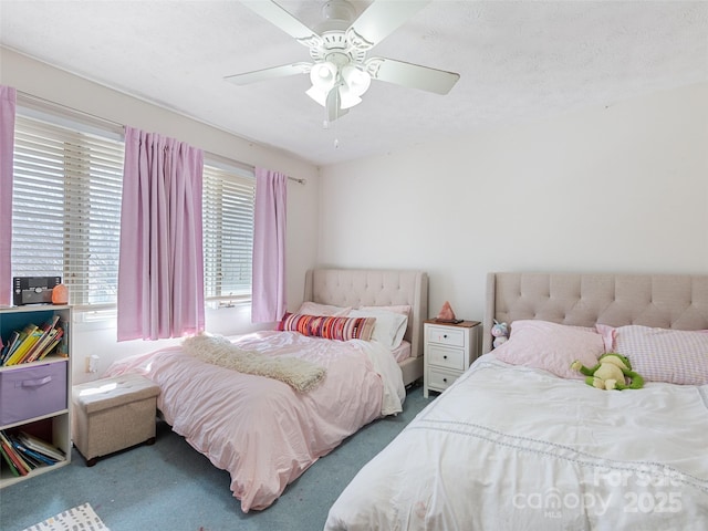 carpeted bedroom featuring a ceiling fan and a textured ceiling