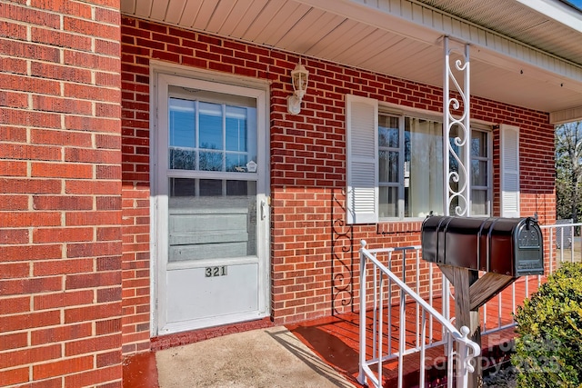 doorway to property with brick siding