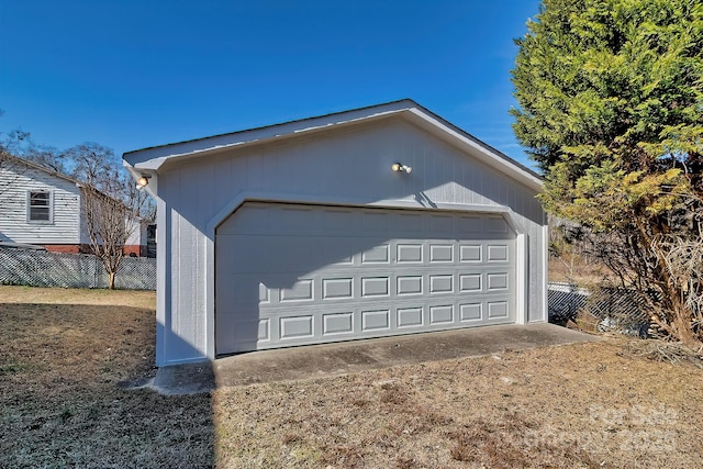 detached garage featuring fence