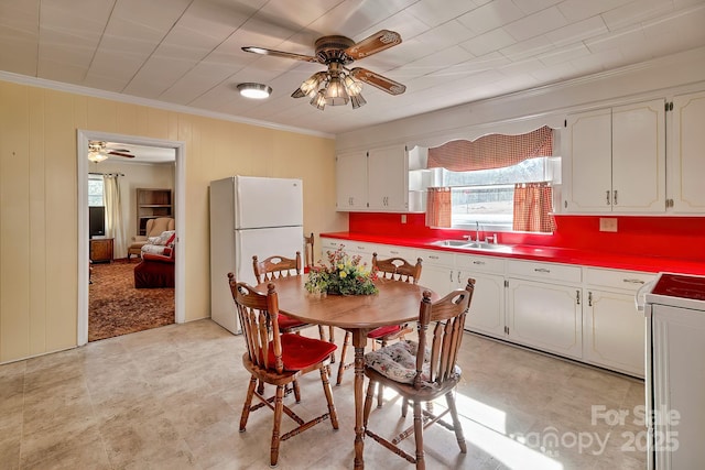 kitchen with freestanding refrigerator, white cabinets, a sink, and ceiling fan