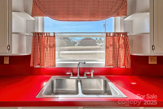 kitchen with white cabinets, plenty of natural light, a sink, and open shelves