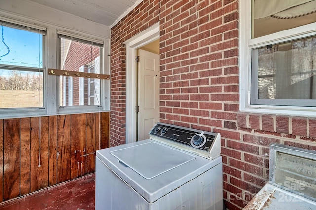 washroom with washer / dryer and brick wall