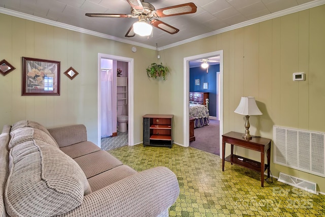 living area featuring a ceiling fan, visible vents, and crown molding