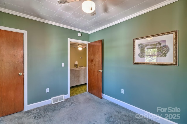 unfurnished bedroom with baseboards, carpet, visible vents, and crown molding