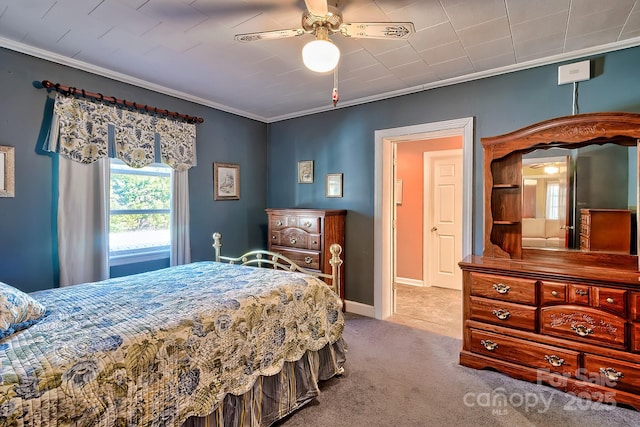 carpeted bedroom featuring ceiling fan, ornamental molding, and baseboards