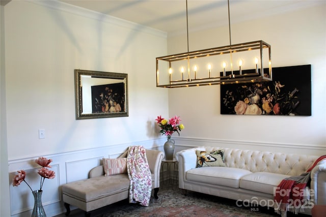 living room with a decorative wall, wainscoting, and crown molding