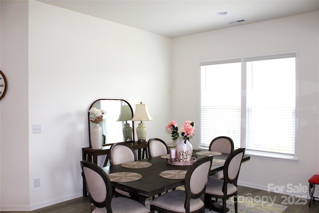 dining space featuring dark wood-type flooring, visible vents, and baseboards