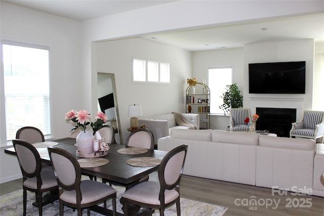 dining area featuring a fireplace and dark wood finished floors