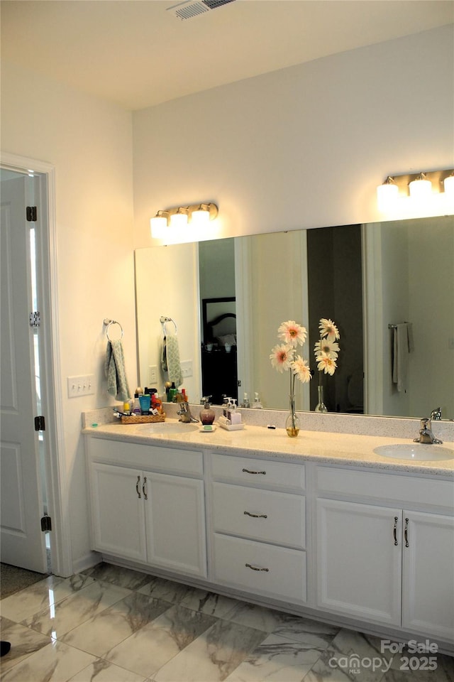 full bath with marble finish floor, visible vents, a sink, and double vanity