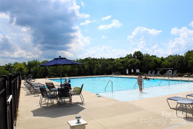 community pool featuring a patio area and fence