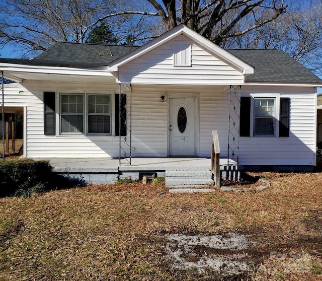 bungalow-style house featuring a porch and roof with shingles