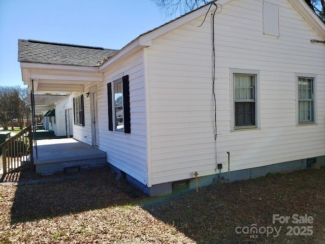 view of side of property featuring covered porch, a shingled roof, and crawl space