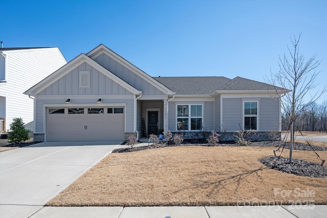 view of front facade with a garage, concrete driveway, a shingled roof, and board and batten siding