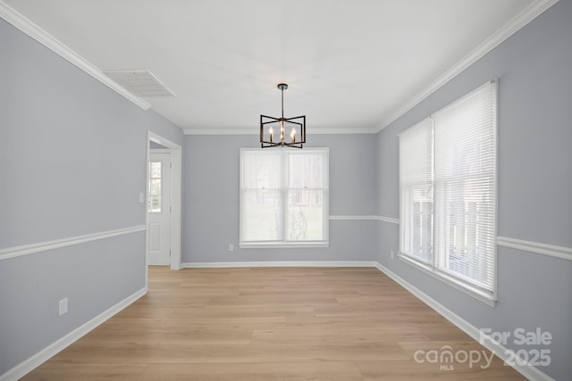 unfurnished dining area with a healthy amount of sunlight, an inviting chandelier, light wood-style flooring, and visible vents