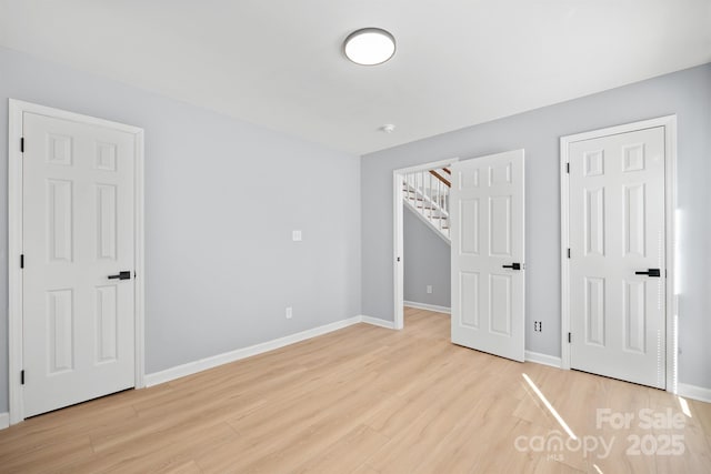 unfurnished bedroom featuring light wood-style flooring and baseboards