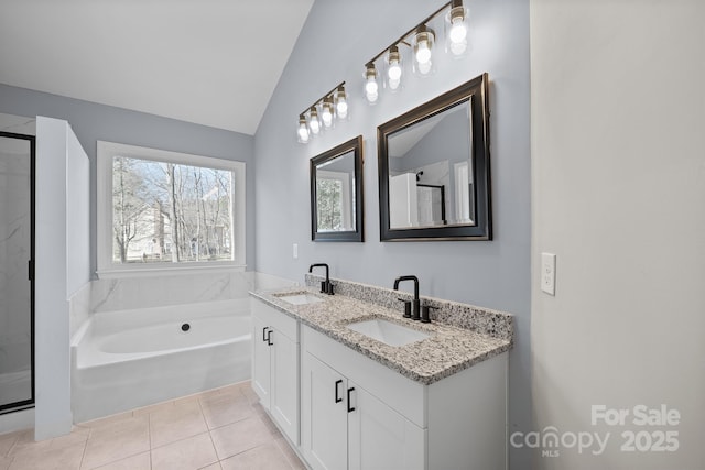 full bathroom with lofted ceiling, tile patterned flooring, a sink, and a garden tub