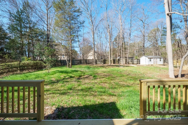 view of yard featuring a fenced backyard, a shed, and an outdoor structure