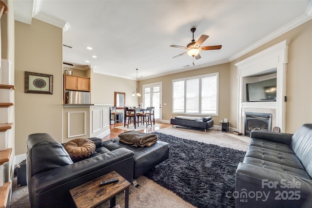 living room featuring ceiling fan, recessed lighting, a fireplace with flush hearth, baseboards, and crown molding