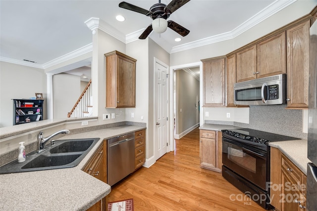 kitchen featuring appliances with stainless steel finishes, brown cabinetry, light countertops, and a sink