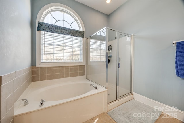 bathroom featuring a wealth of natural light, tile patterned flooring, a shower stall, and a bath