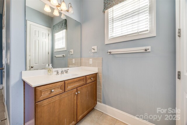 bathroom with a chandelier, vanity, and tile patterned floors