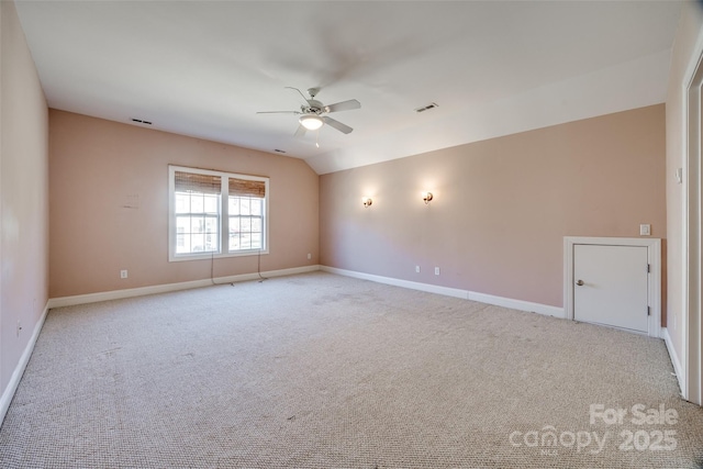 unfurnished room featuring lofted ceiling, light carpet, visible vents, a ceiling fan, and baseboards