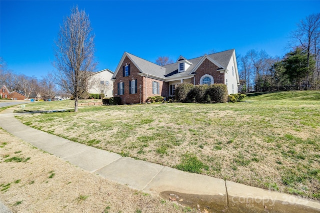 view of front of home with a front lawn and brick siding