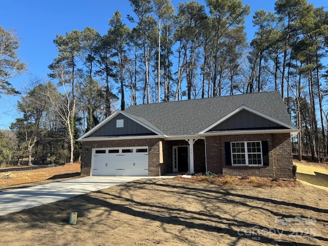 view of front facade with an attached garage, brick siding, a shingled roof, concrete driveway, and board and batten siding