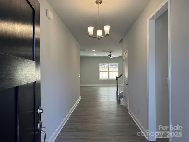 hall featuring dark wood-style flooring, visible vents, baseboards, and stairs